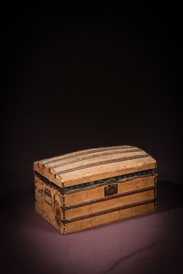 an old wooden box with a striped lid on a dark background