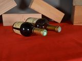 three bottles of wine sitting on a red table cloth