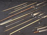 a bunch of different types of knives on a black cloth