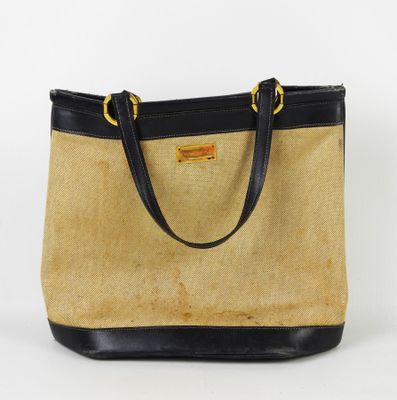 un sac à main beige et noir avec des anses noires sur fond blanc