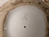 a small vase with a bird on top of it