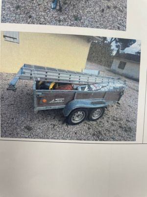 une photo d'un homme debout à côté d'un camion attelé à une remorque
