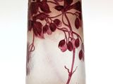 a glass vase that has a purple flower on it