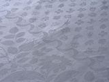 a close up of a white table cloth with a floral design
