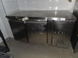 two stainless steel refrigerators in a kitchen with tile flooring