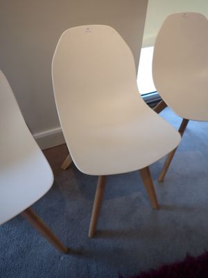 trois chaises blanches dans un coin de la pièce