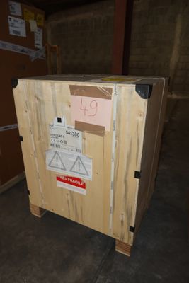 a wooden box with a sign on it in a warehouse
