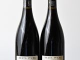 two bottles of wine sitting on top of a table next to each other