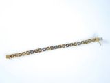 a close up of a gold and silver bracelet on a white surface