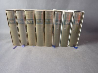 six livres sont alignés sur une surface grise
