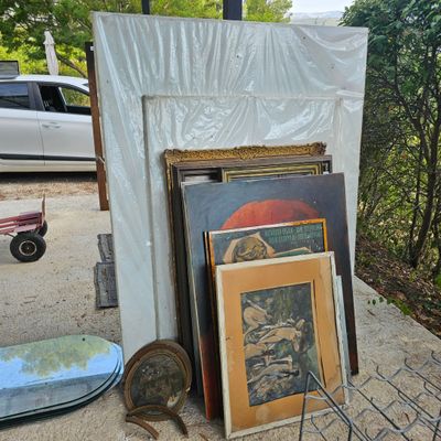 beaucoup d'œuvres d'art posées par terre près d'une voiture