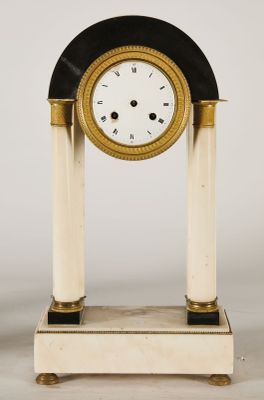 a black and white clock sitting on top of a table