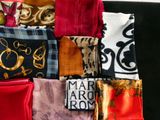 many different types of scarves laid out on a black surface