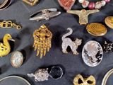 many different types of brooches and jewelry on the table