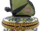 un papillon posé sur une boîte décorée de fleurs