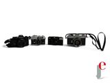 three cameras sitting next to each other on a white surface