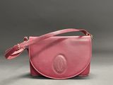 a pink leather purse with a strap and a clasp on it