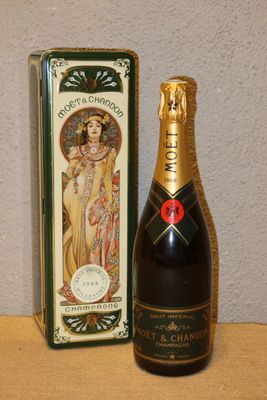 des bouteilles de champagne et une boîte posées sur une table, avec un mur en arrière-plan