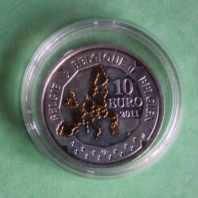 the coin is in a clear plastic container on a green surface
