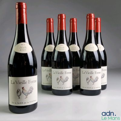 six bottles of red wine are lined up on a table
