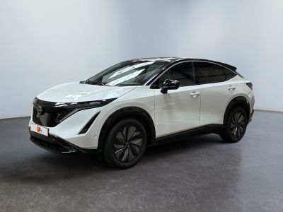 un SUV Nissan blanc garé dans une pièce au sol noir