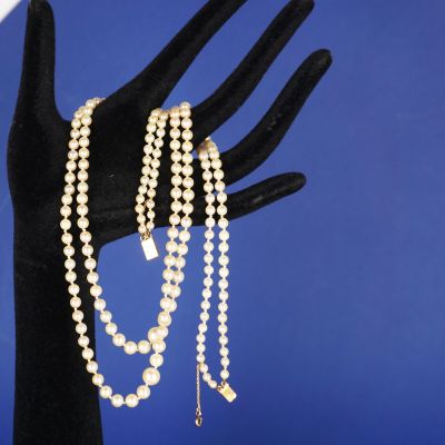 un gros plan sur la main d'une personne tenant un bracelet en perles