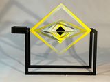 une photo d'une sculpture en verre jaune et noir posée sur un socle