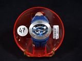 une montre bleue et rouge dans un étui en plastique transparent