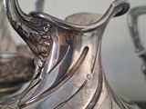 two silver vases sitting on a table next to each other