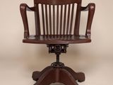 une image représentant une chaise en bois posée sur un socle, avec une assise en cuir marron