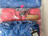 three t - shirts are wrapped in plastic bags on a table