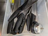 a person holding a knife in a drawer with other kitchen utensils in it