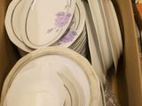 a box full of plates and bowls sitting on the floor