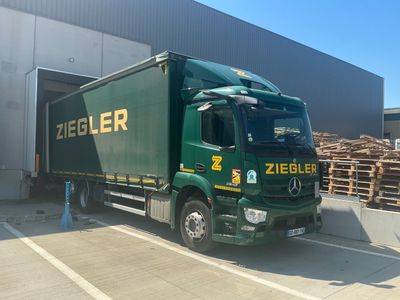 a green truck that is parked in front of a building