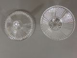 two glass dishes on a table with a white table cloth