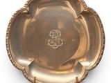 an antique silver plate with a flower design on the rim