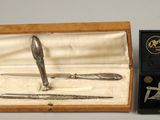 a silver pen in a wooden box next to a pair of scissors