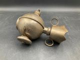 pair of antique brass bells on a metal surface