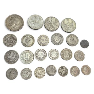 un assortiment de pièces de monnaie en argent et en argent sur une surface blanche