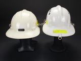 pair of white hard hats on display on black background