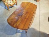 a wooden table with a chair and a chair in the background