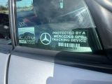 un autocollant apposé sur le côté d'une voiture indiquant « protégé par un dispositif de localisation GPS Mercedes »