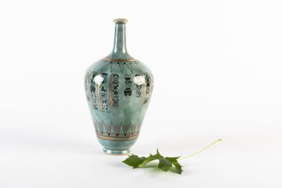 un petit vase avec une feuille par terre
