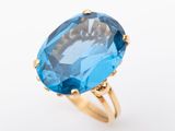 a close up of a blue topaz ring on a white background