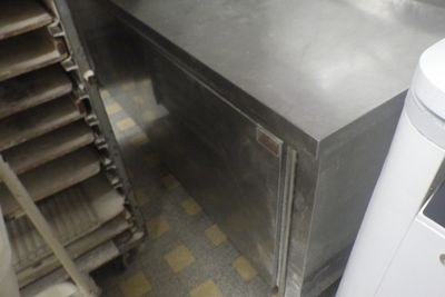 stainless steel counter top in a commercial kitchen with stairs leading up to it