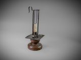 a metal candle holder with a candle on top of it