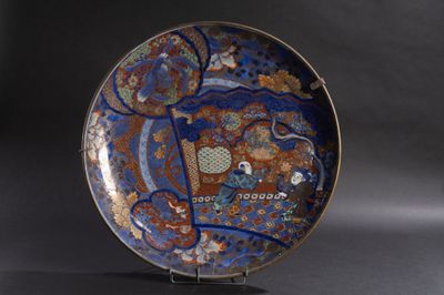 une assiette bleue décorée, posée sur un support