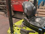 a yellow forklift with a black seat in a warehouse