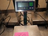 a scale with a pink sticker on it in the middle of a room