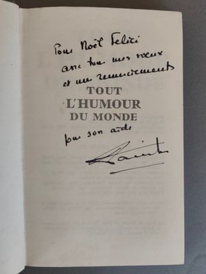 un livre ouvert, sur lequel est posée une note manuscrite, posé sur une table